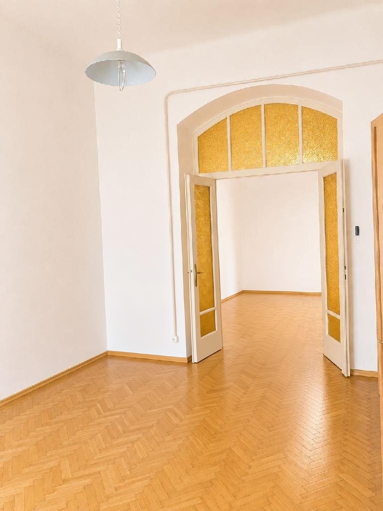 Világos szoba íves, üvegezett ajtóval és függőlámpával