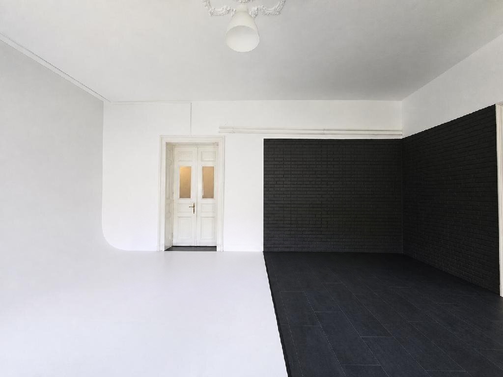 Fotóstúdió-kialakítás fekete téglafallal és fehér háttérrel